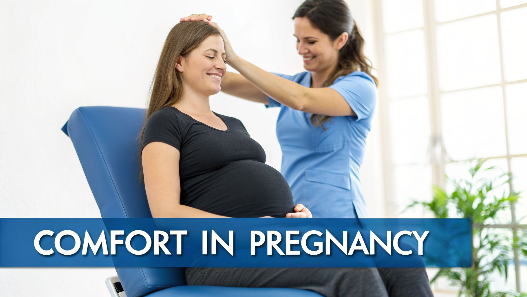 A smiling pregnant woman sitting on an examination table receiving a head adjustment for comfort.